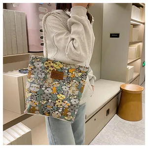 Detailed view of canvas tote bag featuring colorful cartoon cat prints and sturdy rope handles