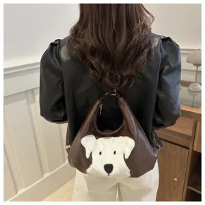 Detailed view of brown tote bag with white plush dog patch shown on model