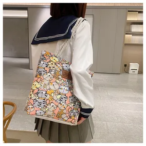 Rear view of a pink canvas tote bag with cat prints and thick rope handles on a model