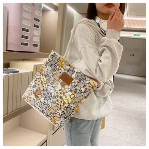 Lifestyle shot of woman wearing a cream canvas tote bag with colorful cartoon cat prints