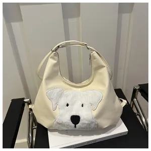 Detail of hobo tote bag featuring a plush 3D dog patch and adjustable leather strap
