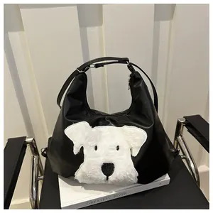 Close-up of black leather tote with white plush dog motif and silver zipper detail