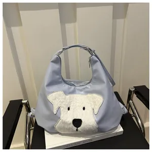 Detail of light blue hobo bag with white plush puppy patch on smooth nylon fabric surface