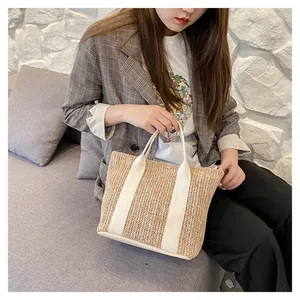 Large hand-woven straw tote bag with cream-white straps for summer beach holidays