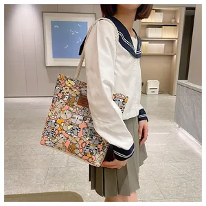 Detail of canvas tote bag with cat pattern, thick rope handles and leather Sport logo