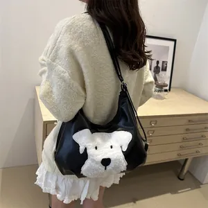 Chic black leather hobo bag with white schnauzer plush detail worn by a model