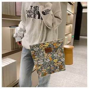 Detail of canvas tote bag with cartoon cat pattern and white cotton rope handles