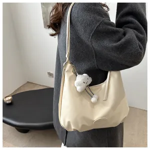 Detail of off-white tote bag with cute cloud charm and smooth PU leather texture