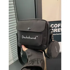Minimalist black nylon crossbody bag with dachshund print and detachable round pouch