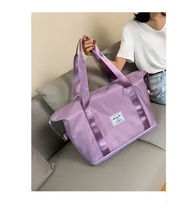 Detailansicht lila Reisetasche mit Markenaufnäher und stabilen Nylon-Tragegriffen