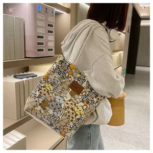 Detail of canvas tote bag with cartoon cat pattern and white rope handles for daily use