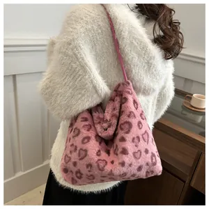 Vista detallada de una mujer con un bolso tote de peluche rosa con estampado de corazón