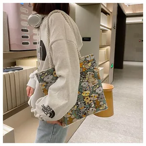 Detail of canvas tote bag featuring colorful cartoon cat prints and thick cotton rope handles
