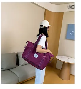 Detailaufnahme der lila Reisetasche aus Nylon mit Schuhfach und Webtragegurt