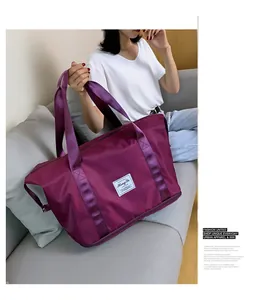 Detailansicht der lila Reisetasche aus Nylon mit breiten Tragegurten und Erweiterungsfach