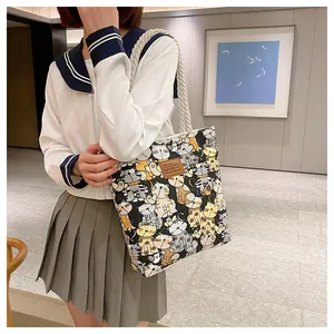 Detail view of canvas tote featuring cartoon cat prints and sturdy rope handles for daily use