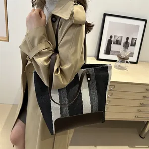 Minimalist striped woven canvas tote bag with brown leather straps for women commuting