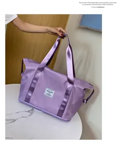 Detailansicht der lila Reisetasche aus Nylon mit Markenaufnäher und breiten Griffen