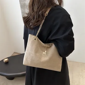 Sac cabas chic en daim beige avec bandoulière chaîne dorée et pendentif cerf élégant
