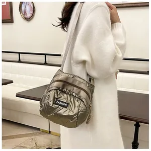 Detail of fashion crossbody bag in olive metallic quilted fabric with logo patch