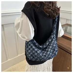 Détail du sac hobo à carreaux bleus et blancs avec bords effilochés et texture frangée