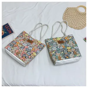 Close-up of canvas tote bags with cute cat patterns, rope handles and leather labels