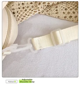 Detailaufnahme des verstellbaren Nylon-Schultergurts mit matter Schnalle an cremefarbener Tasche