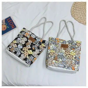 Detail of cartoon cat printed canvas bags with cotton rope handles and sport leather patches