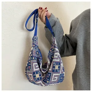 Detail of woven ethnic crossbody bag with geometric patterns and blue nylon strap