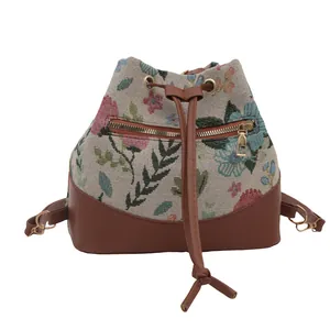 Ethnic style floral jacquard bucket bag with brown leather trim and golden zippers