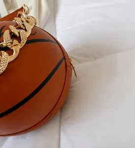 Detail der braunen Basketball-Tasche mit goldener Kette und texturierter PU-Oberfläche
