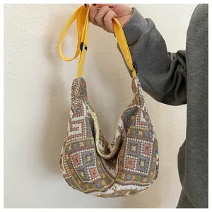 Detailed view of colorful geometric woven fabric and yellow adjustable strap of crossbody bag