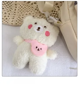 Nahaufnahme eines süßen weißen Plüschbären mit rosa Herztasche an einer Canvas-Tasche