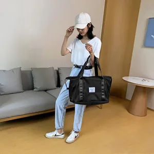 Detailaufnahme der schwarzen Reisetasche aus Nylon mit Tragegriffen und Markenetikett