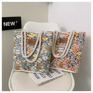 Detailed view of canvas tote bags with cartoon cat prints and sturdy hemp rope handles