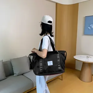 Detail einer großen schwarzen Nylon-Reisetasche mit verstärkten Gurtbandgriffen