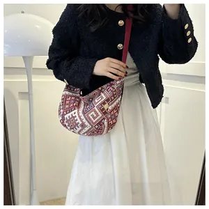 Detailed shot of ethnic knit crescent shoulder bag with colorful geometric patterns