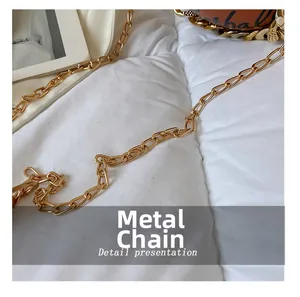 Detalle de la cadena de metal dorada y la tela acolchada blanca del bolso de baloncesto