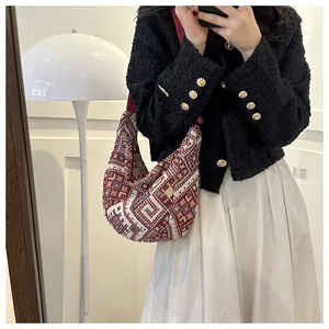 Ethnic style knitted hobo bag with colorful geometric patterns and red fabric strap
