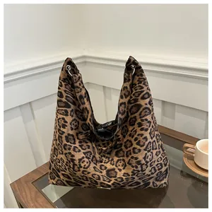 Dettaglio borsa tote leopardata in pelle scamosciata con chiusura a coulisse e anelli