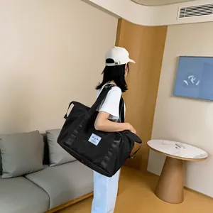 Große schwarze Reisetasche mit verstärkten Gurten und Logo in moderner Wohnumgebung
