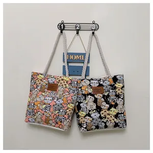 Close-up of dual canvas tote bags with cartoon cat prints and thick rope handles