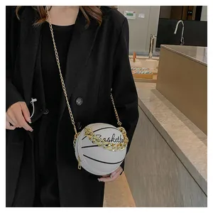Detail shot of a white basketball-shaped crossbody bag with gold chain and black text