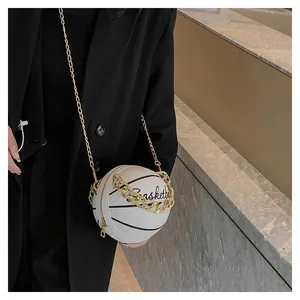 Detailed close-up of a white basketball shaped handbag with gold chain and strap