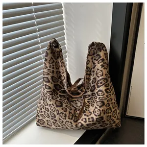 Detail of large leopard print tote bag with brown strap and silver metal ring hardware