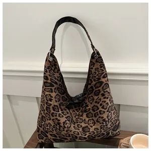 Detail of leopard print tote bag with black leather bow and stylish shoulder strap