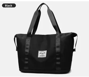 Detalle del bolso de viaje negro con compartimento inferior con cremallera y logo patch