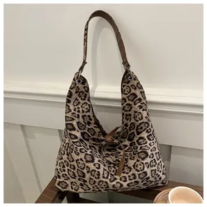 Detailed view of leopard print tote bag with brown leather strap and bow decoration