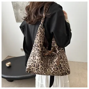 Detail of leopard print tote bag with brown bow knot and handmade metal tag