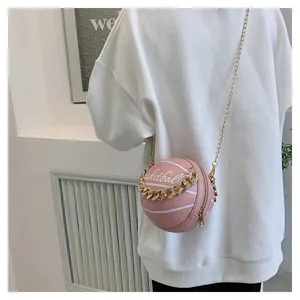 Detail of pink basketball shaped crossbody bag with gold chain and artistic print